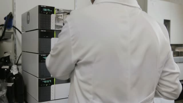 A-handheld-shot-of-a-researcher-checking-a-HPLC-in-a-genetic-laboratory-at-university