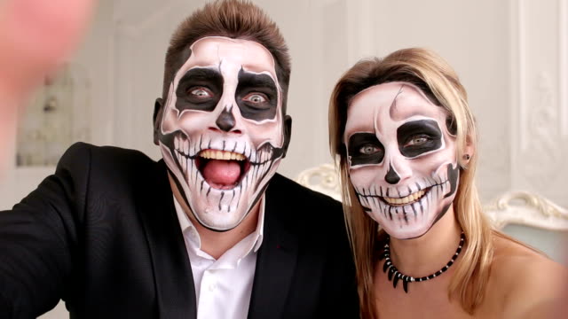 Creepy-couple-with-scary-Halloween-makeup-make-selfies-in-a-studio.