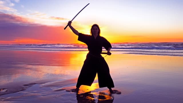 Samurai-Frau-am-Strand-bei-Sonnenuntergang