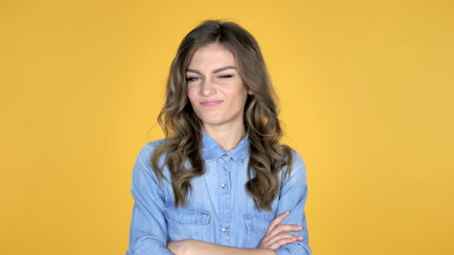Young-Girl-Shaking-Head-to-Reject-Isolated-on-Yellow-Background