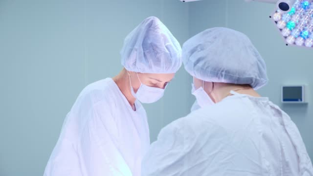 Ärzteteam-chirurgische-Tätigkeit-in-hellen-modernen-OP-Saal.