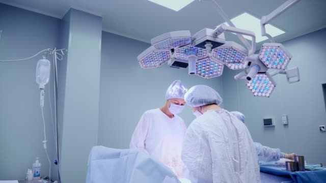 Equipo-médico-realizar-la-operación-quirúrgica-en-quirófano-moderno-brillante.