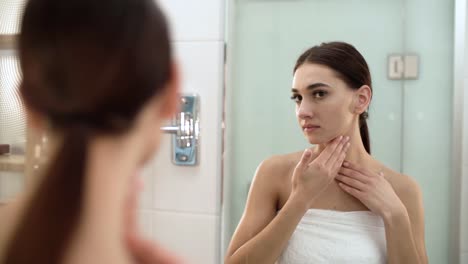 Skin-Care.-Woman-Touching-Face-And-Looking-At-Mirror-At-Bathroom