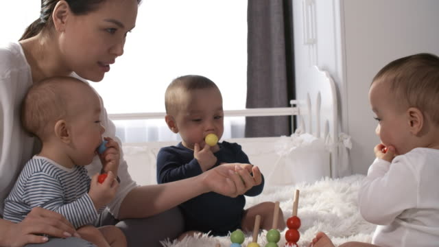 Asiatische-Frau-entfernen-Spielzeug-aus-Baby-Mund