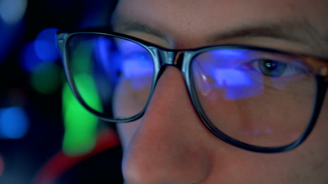 Close-up-of-gamer's-glasses-with-a-videogame-reflecting-in-them