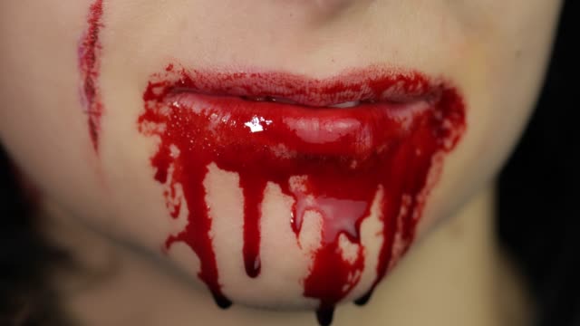 Blutiger-Mund-und-Zähne-des-Mädchens.-Vampir-Halloween-Make-up-mit-tropfendem-Blut