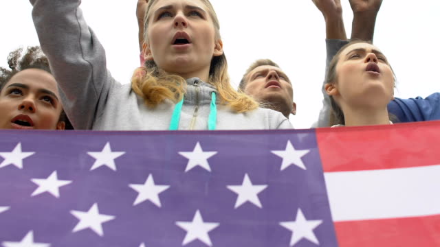 Junge-Aktivisten-mit-US-Flagge-skandieren-Namen-des-Präsidentschaftskandidaten,-Kampagne