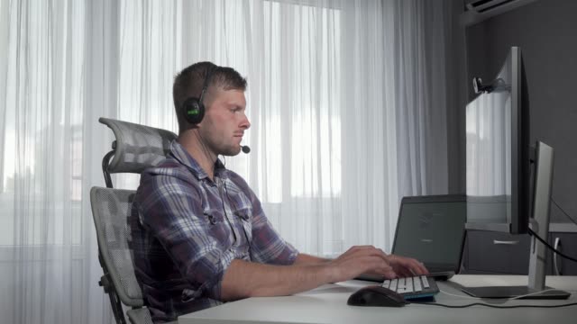 Handsome-customer-support-operator-typing-on-a-computer