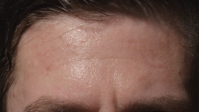 Man-wipes-his-sweating-forehead---Close-up