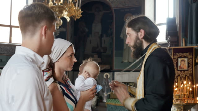 La-madre-besa-una-cruz-durante-el-ritual-de-bautizar-de-su-hijo-en-la-iglesia