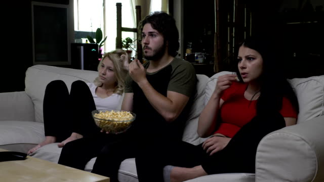 Friends-eating-popcorn-and-watching-horror-movie-with-very-expressive-faces