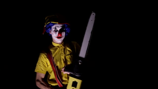 A-clown-comes-out-of-the-dark-with-a-chainsaw.