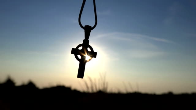 Closeup-Of-Silhouette-Cross-Hanging-at-sunset/sunrise-time
