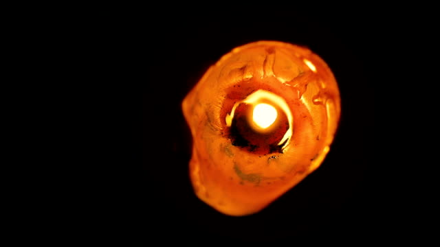 Closeup-abstract-of-a-large,-lone-wax-candle-burning-view-from-the-top-in-slow-motion.