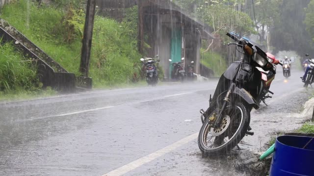 Traffic-along-a-typical-street-on-the-road-during-the-rain-in-Ubud,-island-Bali,-Indonesia