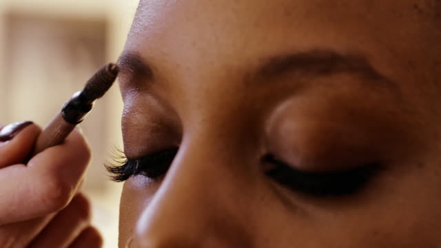 Make-up-Artist-mit-Bürste-Kämmen-Augenbrauen-zupfen-und-Korrektur