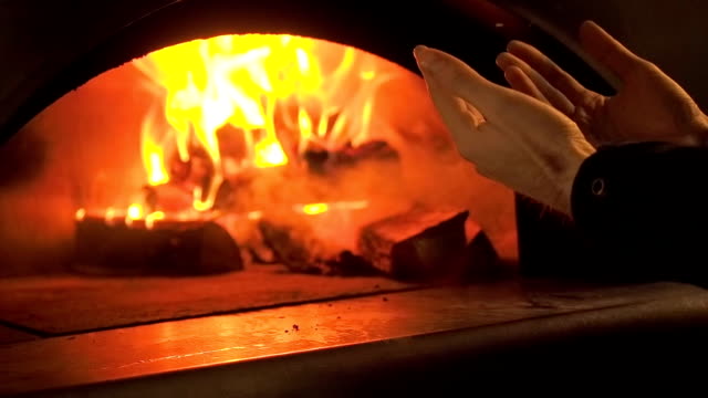Man-Warms-His-Hands-by-the-Fire.-Furnace-Fire.-Video-Clip-of-Burning-Firewood-in-the-Fireplace.-Firewood-Burn-in-the-wood-burning-stove.-30fps-Full-HD