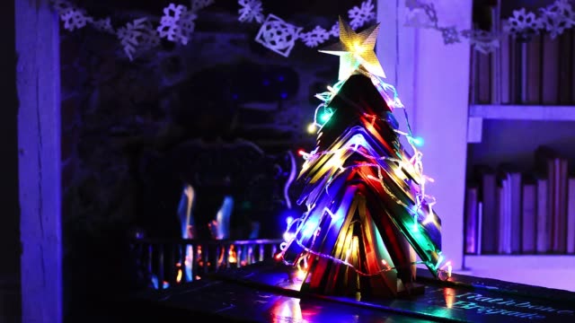 Weihnachtsbaum-aus-Büchern-mit-Feuer-und-Licht-gemacht.