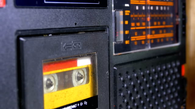 Die-Vintage-gelb-Audio-Kassetten-in-den-alten-Kassettenrekorder-dreht-sich