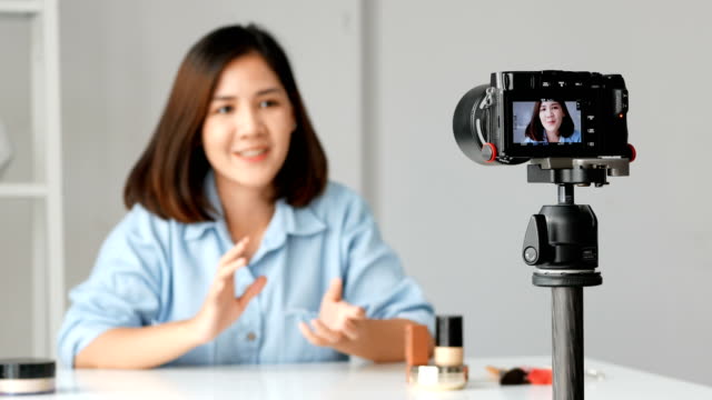 Mujer-asiática-joven-belleza-blogger-de-moda-grabar-video-Presen-su-producto.-tiro-de-cámara.
