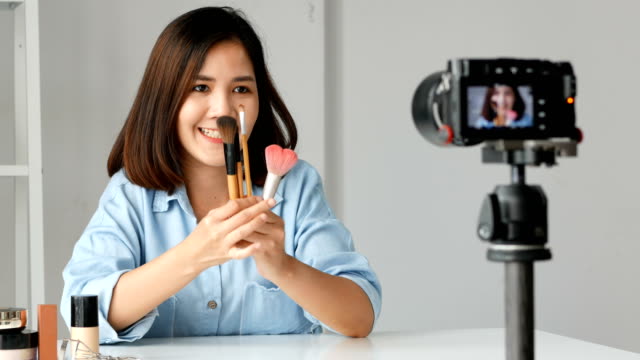 Mujer-asiática-joven-influyente-blogger-de-moda-belleza-grabación-video-Presen-su-producto.-tiro-de-cámara.