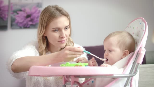 Baby-don't-want-eating-food.-Mother-feeding-child-with-porridge