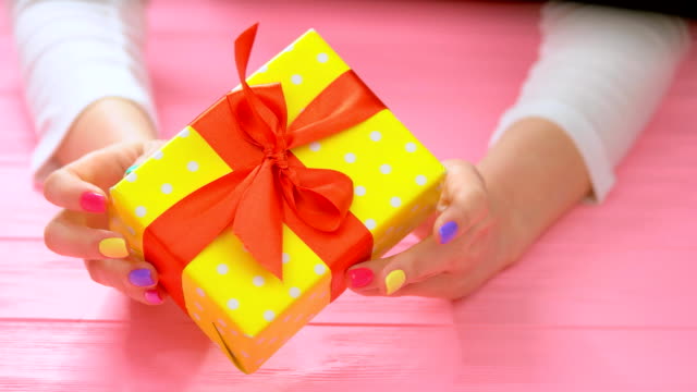 Gift-box-in-female-manicured-hands.
