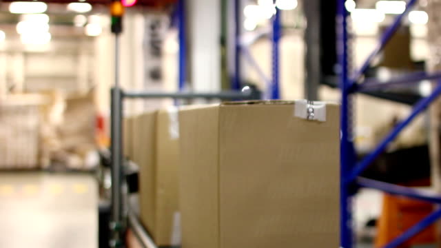 Cajas-de-cartón-en-cinta-transportadora-dentro-de-almacén