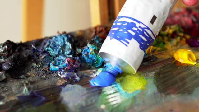 artist-squeezes-paint-out-of-tube-into-palette