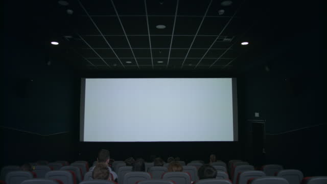 Zuschauer-im-Kinosaal-betrachten-weißer-Bildschirm-in-Erwartung-des-Film-show