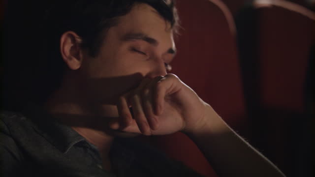 Hombre-bostezando-en-la-silla-del-cine.-Chico-guapo-para-dormir-en-el-cine.-Enorme-hombre-dormido