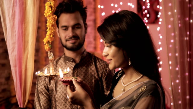 A-happy-and-attractive-couple-in-a-house-interior-decorated-with-lights-and-flowers.