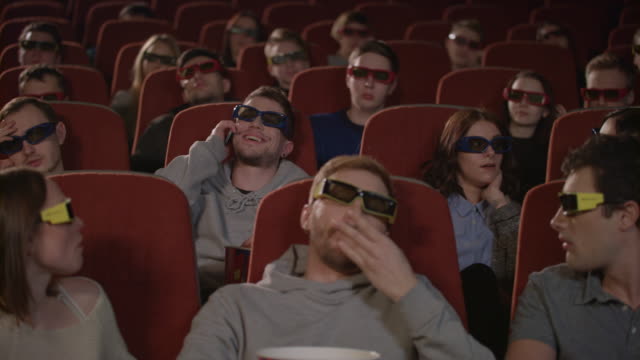 Man-talking-on-phone-in-cinema-hall.-Uncultured-man-disturb-people-in-cinema