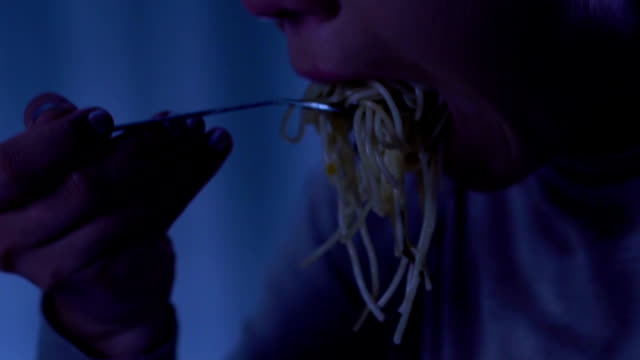 Mujer-triste-comer-espaguetis-y-llorando,-sufriendo-de-bulimia,-abrigo-sin-hogar