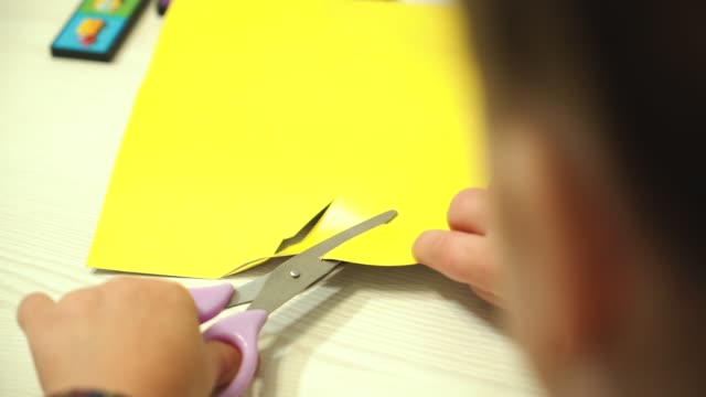 Child-cuts-paper-with-scissors.