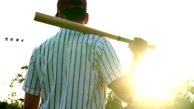 Herren-Baseball-Praxis-schlagen-einen-Baseball-mit-dem-Licht-des-Sonnenuntergangs