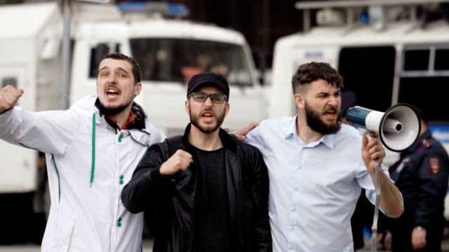 Wütend-Fußball-Fans-schreien-auf-Straße-in-ein-Megaphon.-Kaukasische-Leute-streiken.