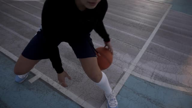 Female-basketball-player-in-morning-light-on-professional-court-running-with-ball.-Handhelded-footage.-Close-up