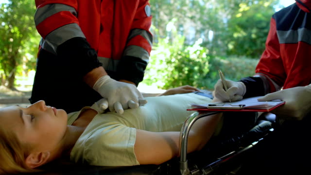 Paramédico-haciendo-CPR-para-chica,-hacer-registros,-profesional-de-ahorro-vida-colega