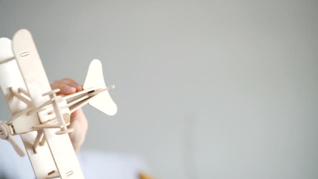 Slow-motion-footage-of-the-boy`s-hand-playing-with-wooden-plane-toy-model