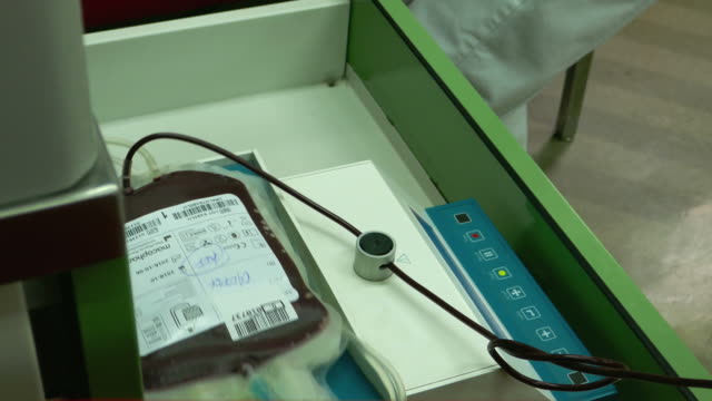 Material-de-archivo-en-el-Departamento-de-la-transfusión,-una-persona-es-donar-sangre,-se-muestra-en-el-tiro-una-bolsa-de-sangre-y-la-sangre-fluye-en