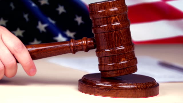 Judge-hand-striking-gavel,-US-flag-on-background,-american-legal-system,-justice