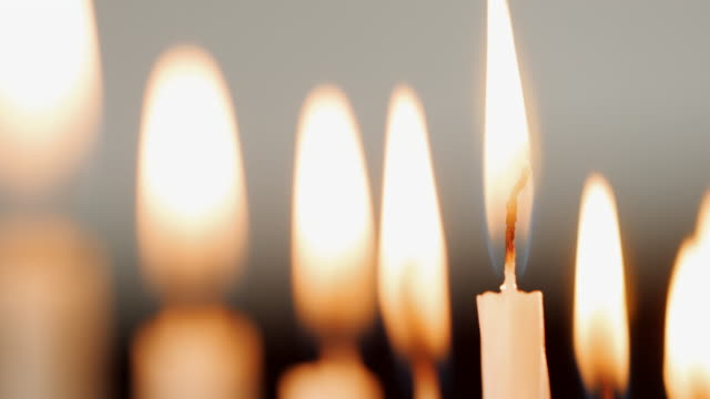 Detail-Aufnahme-der-Flammen-auf-eine-Gruppe-von-weißen-Kerzen-brennen-für-die-jüdischen-Feiertag-von-Hanukkah,-die-ausgeblasen-werden,-selektiven-Fokus