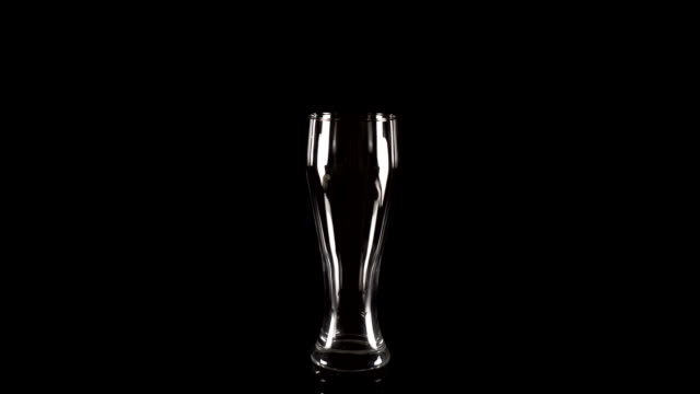 leeres-Bierglas-dreht-sich-auf-einem-schwarzen-Hintergrund