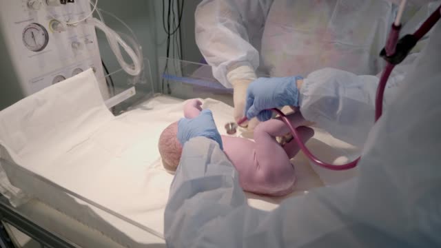 Newborn-cute-infant-baby-with-hand-holding-clip-on-umbilical-cord-at-a-hospital-nursery.
