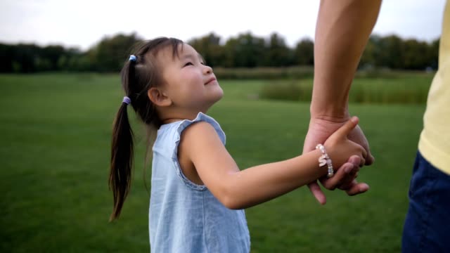 Asian-father-and-daughter-holding-hands-and-walking