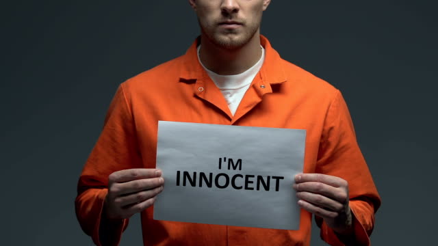 Im-innocent-phrase-on-card-in-hands-of-Caucasian-prisoner,-criminal-injustice