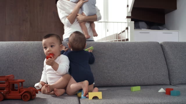 Baby-Brother-mit-seinen-Zwillingsgeschwistern-auf-der-Couch