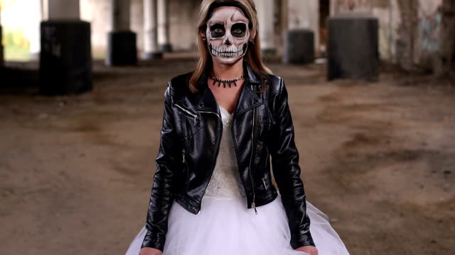 Girl-in-wedding-dress-and-in-a-leather-jacket-with-a-terrible-make-up.-Halloween
