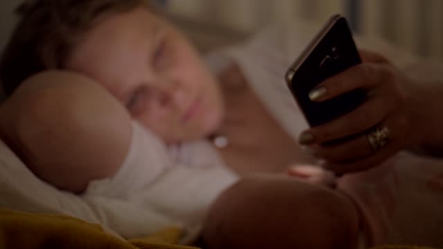 Mujer-que-usa-el-móvil-cuando-amamanta-al-bebé-por-la-noche